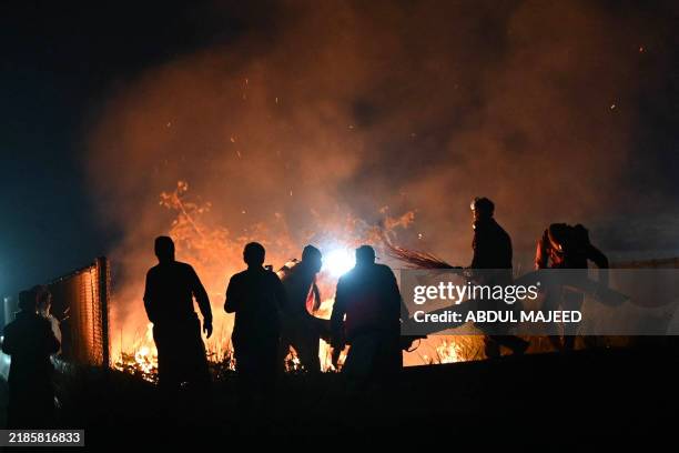 Supporters of jailed former Pakistan's prime minister Imran Khan's Pakistan Tehreek-e-Insaf party set fire to bushes during a protest demanding his...