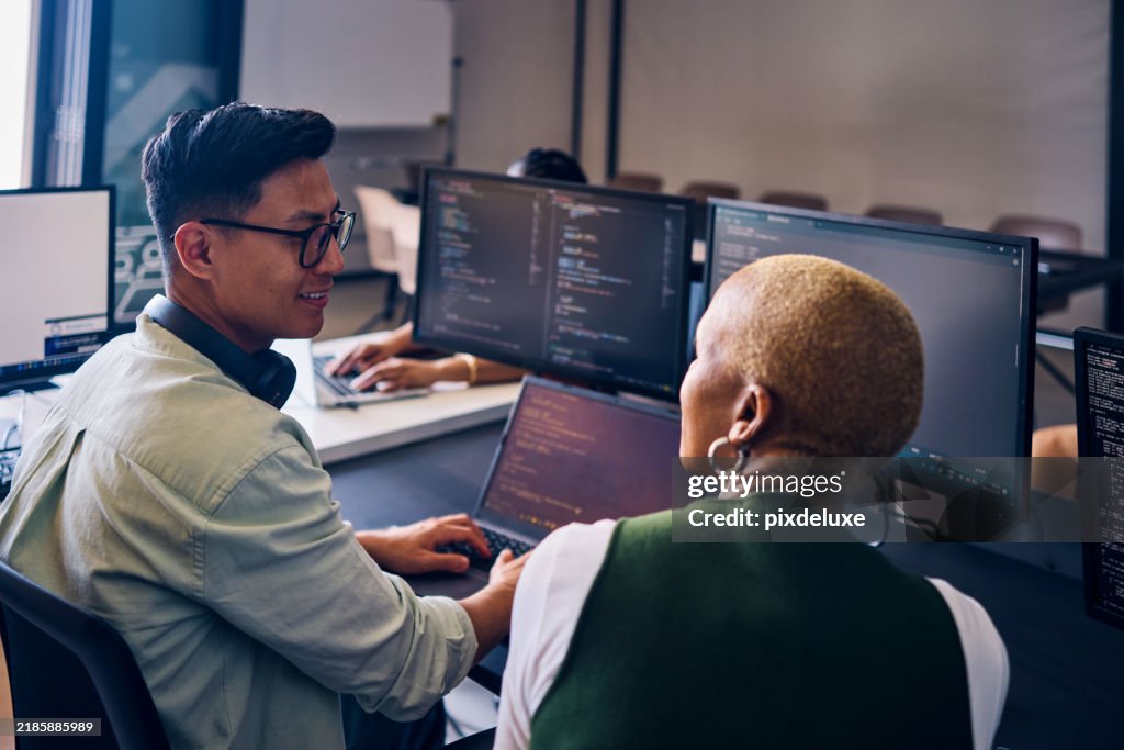 Focused asian computer programmer working on code in office