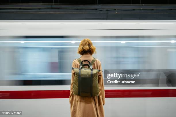 rear-view of a mid-adult woman waiting for a subway train in rome in italy - esperar imagens e fotografias de stock