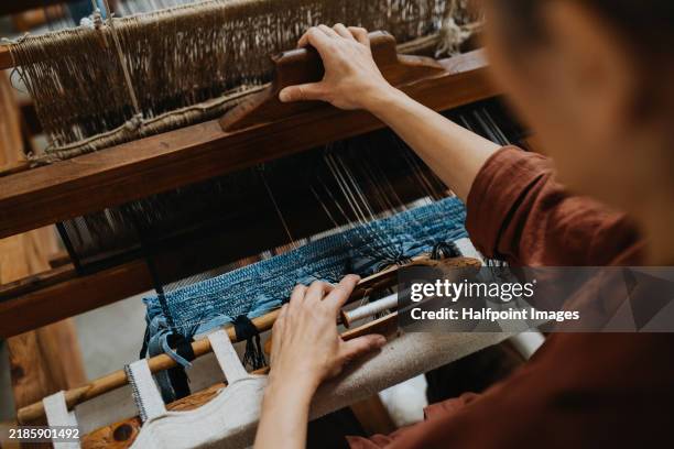 close up of wooden loom with old jeans fabric. woman weaving handmade product from upcycled old fabrics, textile. weaving small business and circular economy. - textielindustrie stockfoto's en -beelden