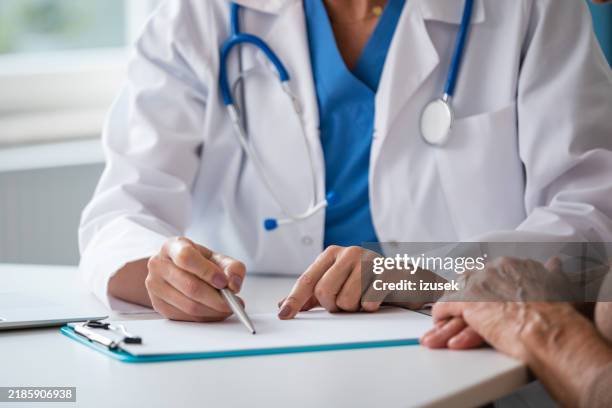 female doctor discussing test results with senior woman - medical insurance stock pictures, royalty-free photos & images