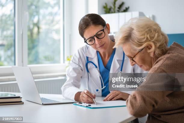 female doctor discussing with senior woman - discussion stock pictures, royalty-free photos & images