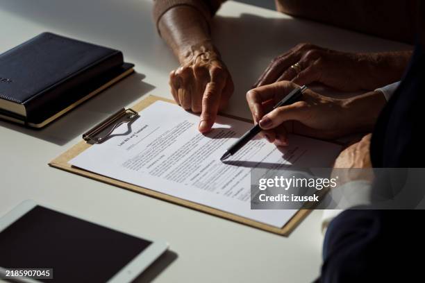 senior woman discussing the will with lawyer - law office stock pictures, royalty-free photos & images
