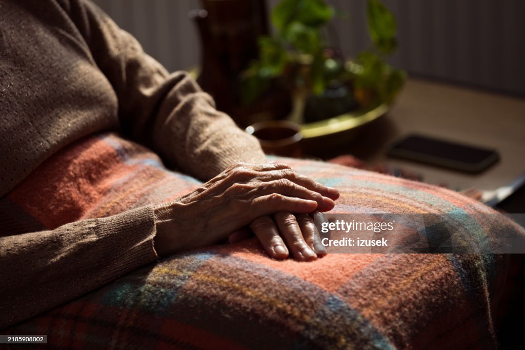 Mani di donna anziana sulla coperta