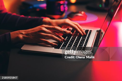 Female Programmer Writing Code on Laptop in Dim Lighting Female Programmer Writing Code on Laptop in Dim Lighting