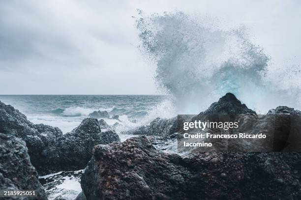 ocean wave and volcanic rocks - tipo de roca fotografías e imágenes de stock