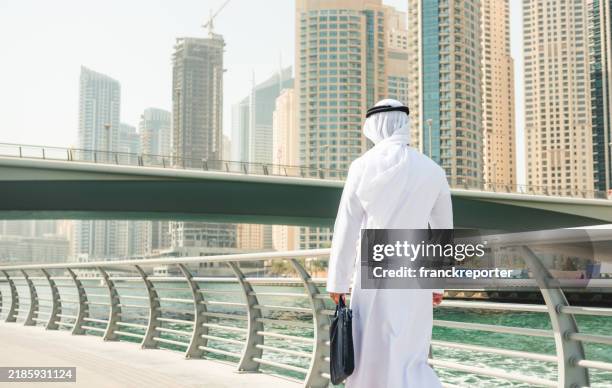 sheik man walking in dubai marina - the city walk dubai stock pictures, royalty-free photos & images