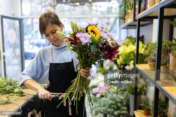 florist in her flower shop - flower shop stock pictures, royalty-free photos & images