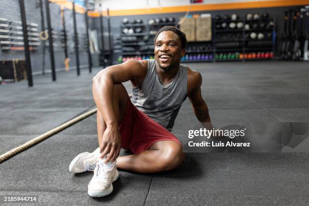 young african man relaxing after workout at cross training gym. - body building photos et images de collection
