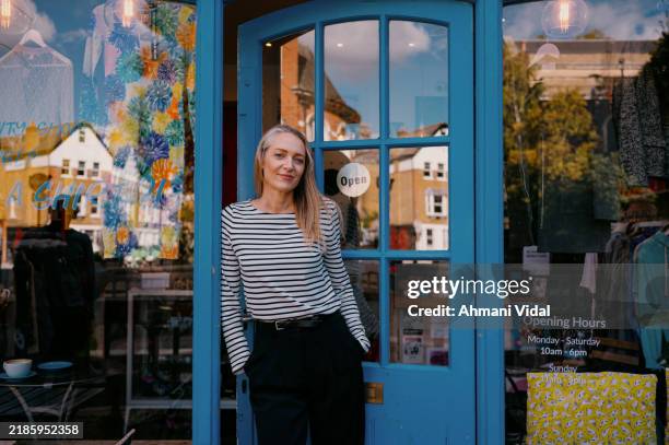 portrait of a confident shop owner standing in the doorway of their small shop - owner stock pictures, royalty-free photos & images