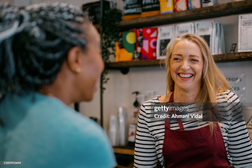 A barrista smiles at a customer she's serving