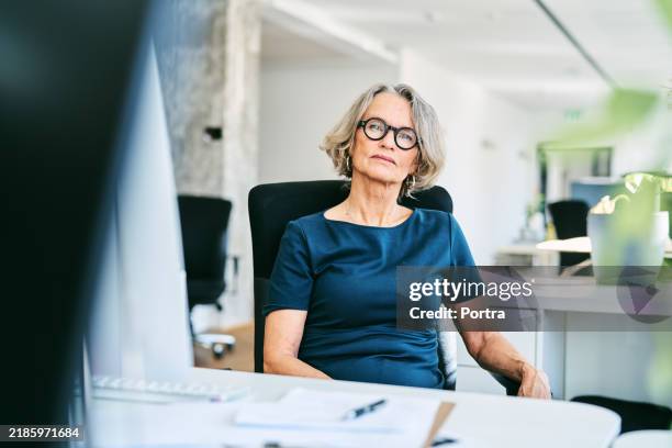 porträt einer selbstbewussten geschäftsfrau, die im büro sitzt - einzelne frau über 40 stock-fotos und bilder