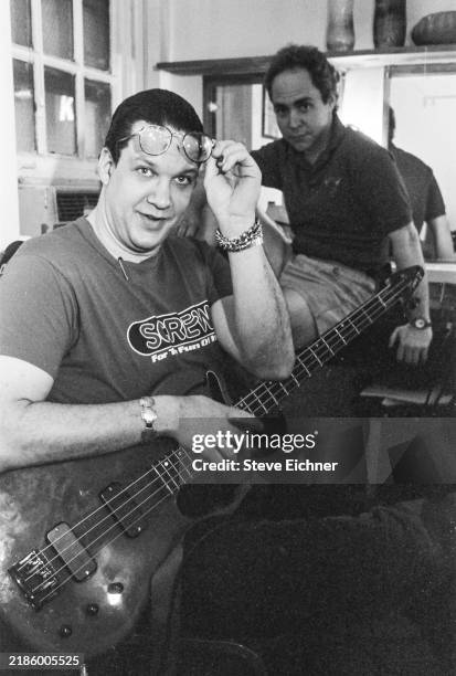 Portrait of American magicians Penn Jillette, holding a bass guitar, and Teller , of the duo Penn & Teller, as they pose, before a performance of...