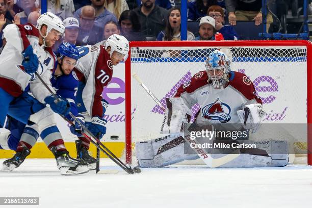 Justus Annunen of the Colorado Avalanche looks to make a save as Anthony Cirelli of the Tampa Bay Lightning fights for position between Mikko...