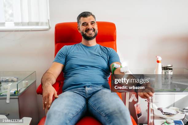 mid-adult man donating blood in a hospital - doação de sangue imagens e fotografias de stock