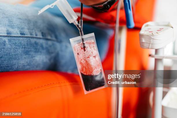 mid-adult man donating blood in a hospital - blood bank stock pictures, royalty-free photos & images