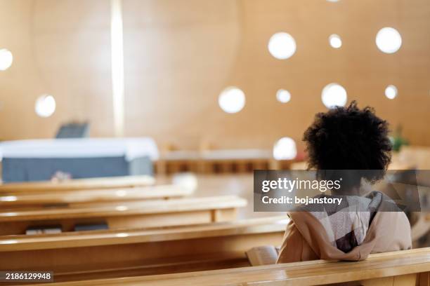 woman reading bible in the church - protestantismus stock-fotos und bilder