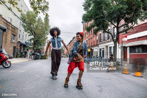 couple of friends on roller skates and penny board in williamsburg nyc - skater stock pictures, royalty-free photos & images