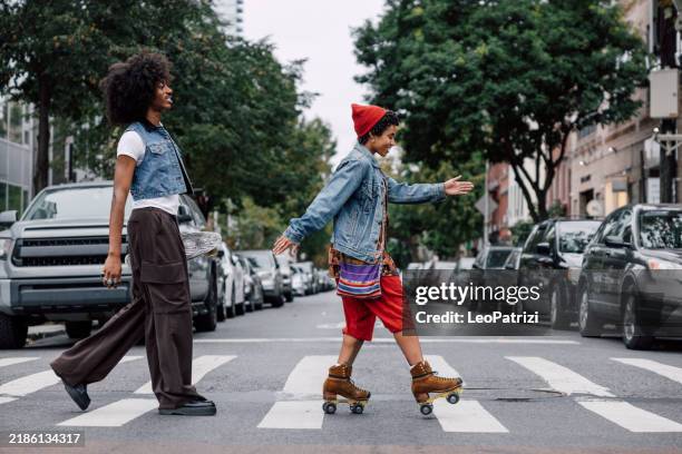 couple of friends on roller skates and penny board in williamsburg nyc - couple crossing street stock pictures, royalty-free photos & images