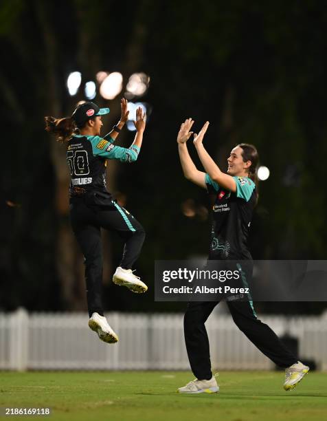 Jemimah Rodrigues of the Heat celebrates with Lucy Hamilton after catching out Annabel Sutherland of the Stars during the WBBL match between Brisbane...