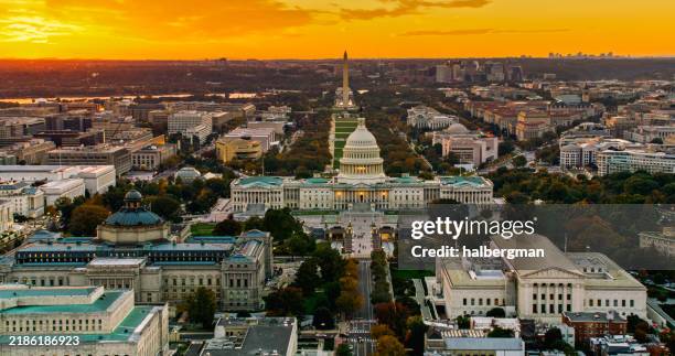 orange sunset sky behind capitol complex and washington monument - capitólio capitol hill imagens e fotografias de stock