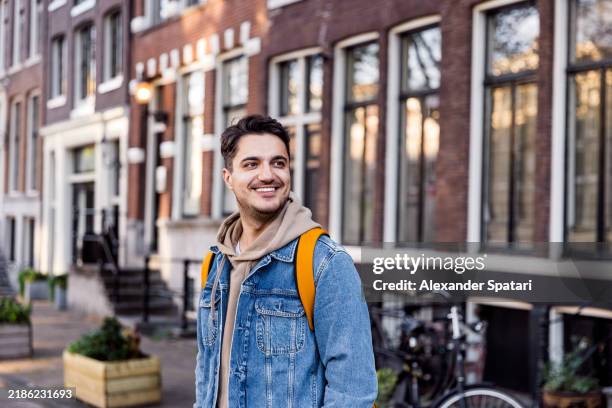 portrait of a man on the street in amsterdam historic center, netherlands - explorer stock pictures, royalty-free photos & images