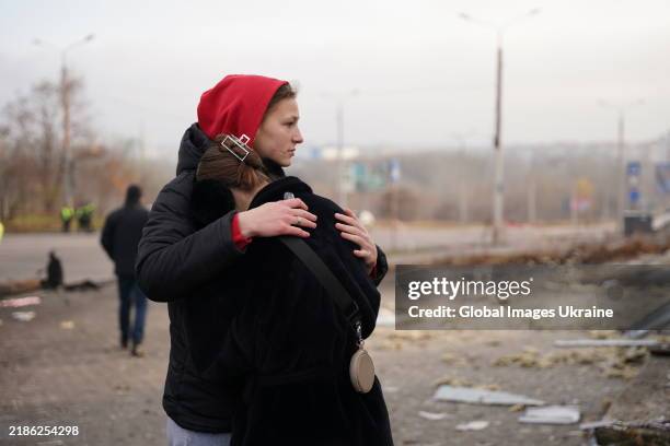 Woman cries on friend's shoulder at the site of a Russian kamikaze drone's strike on the city's residential area on November 22, 2024 in Sumy,...