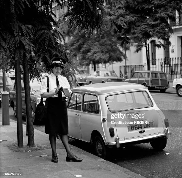 Une femme agent de police rédige une contravention, en 1967, à Londres, en Angleterre au Royaume-Uni.