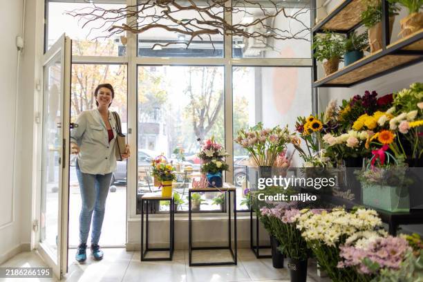 donna che entra in un negozio di fiori - entrare foto e immagini stock