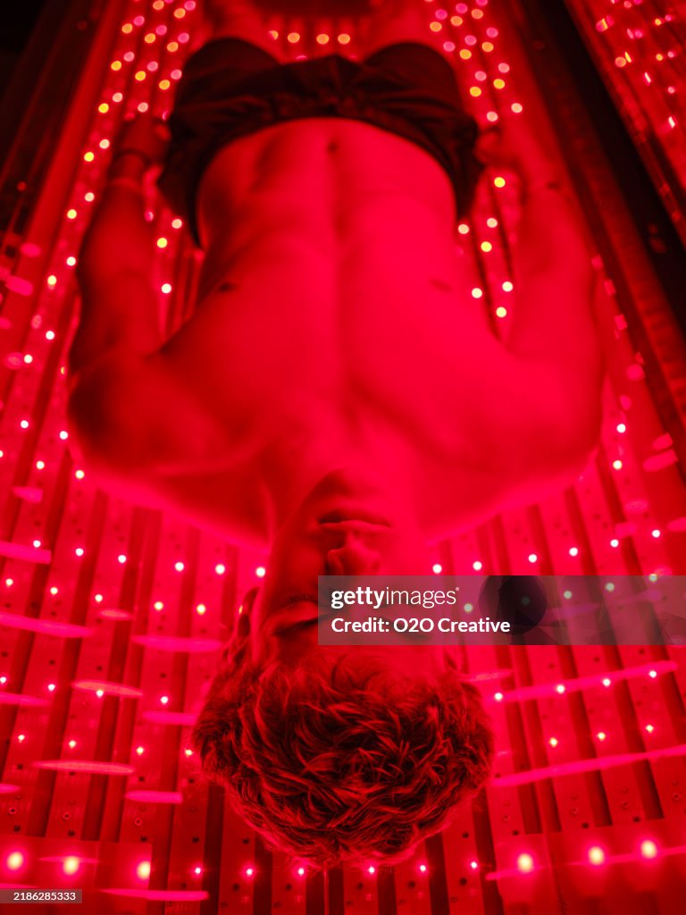 Young Man On an LED Bed Receiving Red Light Therapy