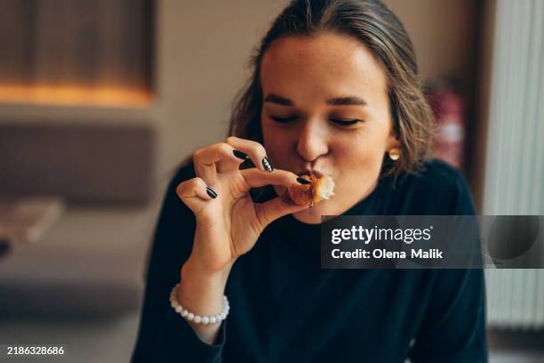 young woman enjoying coffee and croissant in a cozy café - comfort food - fotografias e filmes do acervo