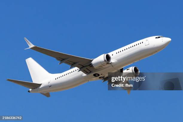 white passenger aircraft in the blue sky - voar imagens e fotografias de stock