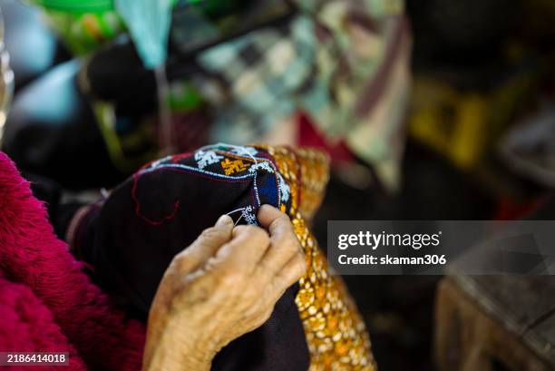 close up hand of senior hilltribe sewing traditional hilltribe pattern and cloth - asian market stock pictures, royalty-free photos & images