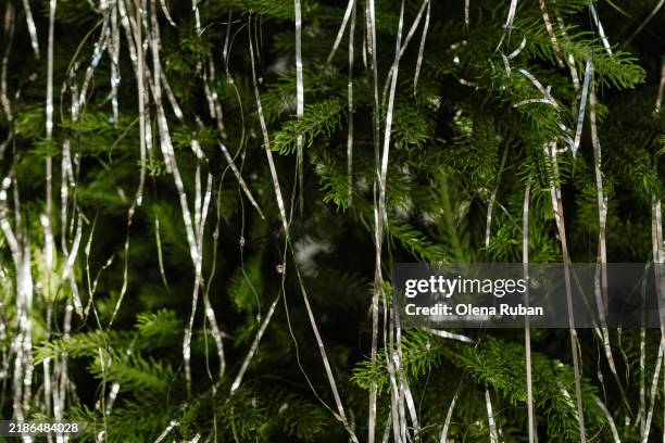 tinsels on a coniferous tree with garlands. - lametta stock-fotos und bilder