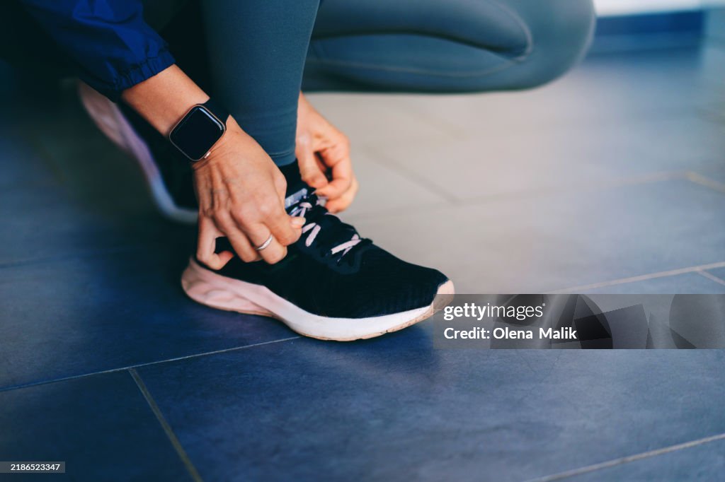 Woman Preparing for a Workout: Tying Running Shoes