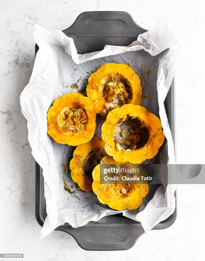 Fresh slices of acorn squash on parchment paper