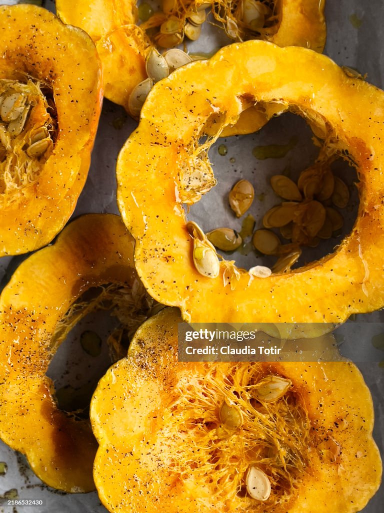 Close-up of fresh slices of acorn squash on parchment paper