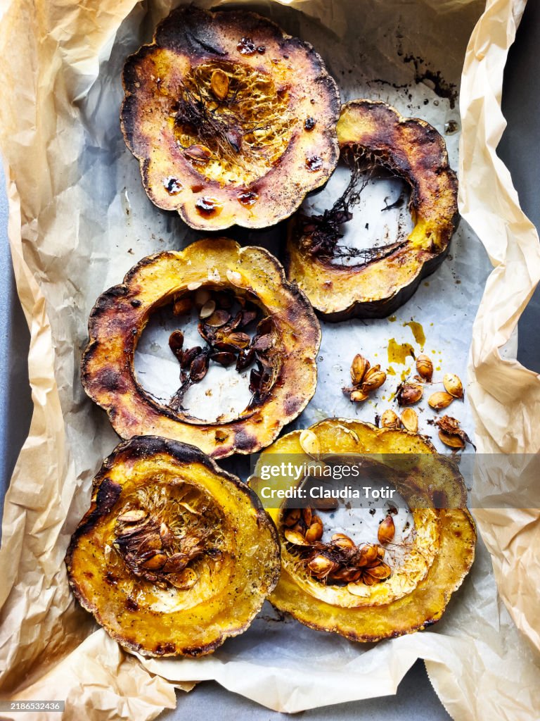 Cooked slices of acorn squash on parchment paper