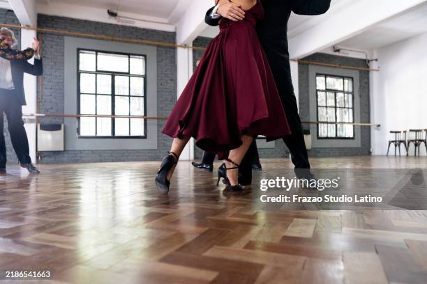 nahaufnahme der beine von tänzern, die in einem tanzstudio tango tanzen - tango tanz stock-fotos und bilder
