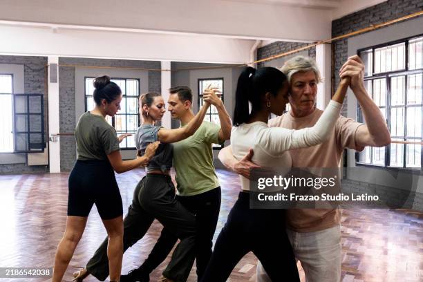 instructor teaching students during tango class - tango stock pictures, royalty-free photos & images