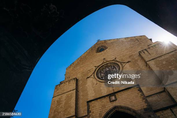 historic church facade with rose window against blue sky - simbolismo imagens e fotografias de stock