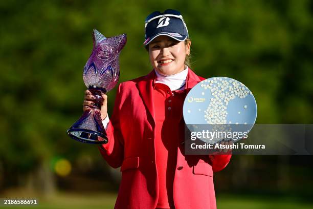 Shiho Kuwaki of Japan poses with the trophies after winning the tournament following the final round of JLPGA Tour Championship Ricoh Cup at Miyazaki...