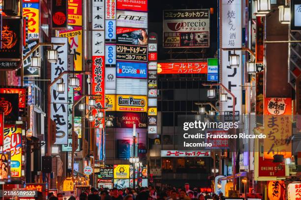 illuminated neon signs in shinjuku, tokyo, japan - shibuya stock-fotos und bilder