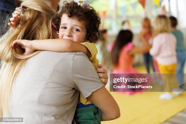 a mother hugs a crying boy in the playroom - teacher crying stock pictures, royalty-free photos & images