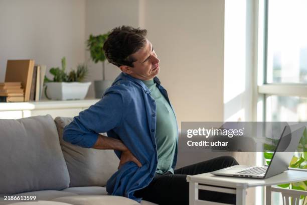 man working from home suffering from back pain - verkeerde-houding stockfoto's en -beelden