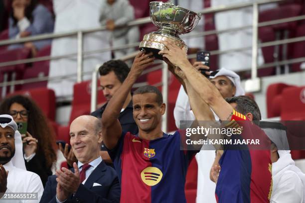 Barcelona's Brazilian forward Rivaldo celebrates with the trophy after winning the Legends El Clasico football match between Real Madrid and...