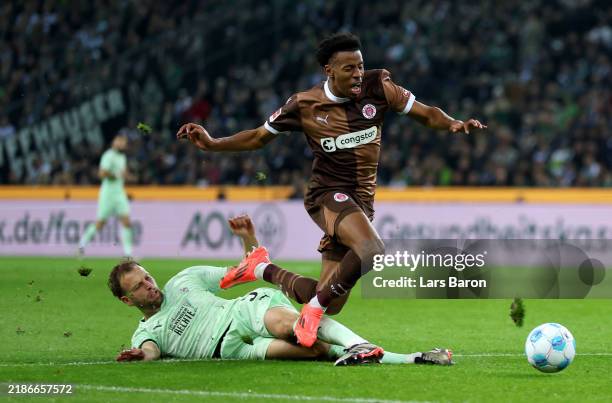 Oladapo Afolayan of FC St. Pauli 1910 is challenged by Marvin Friedrich of Borussia Moenchengladbach during the Bundesliga match between Borussia...