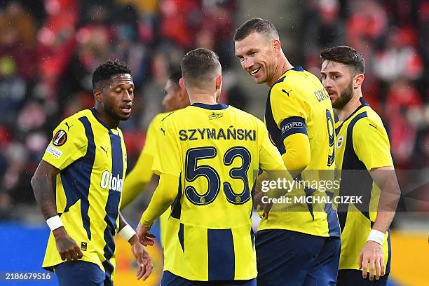 Fenerbahce's Bosnian forward Edin Dzeko is celebrated by team mates after scoring his team's first goal during the UEFA Europa League football match...