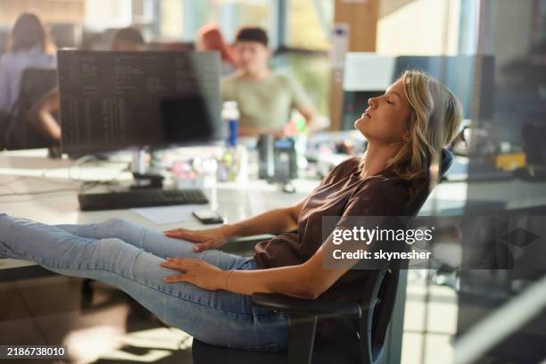 female designer taking a break in the office. - feet up stock pictures, royalty-free photos & images