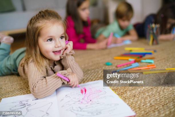little girl is coloring a coloring book at home - coloring stock pictures, royalty-free photos & images